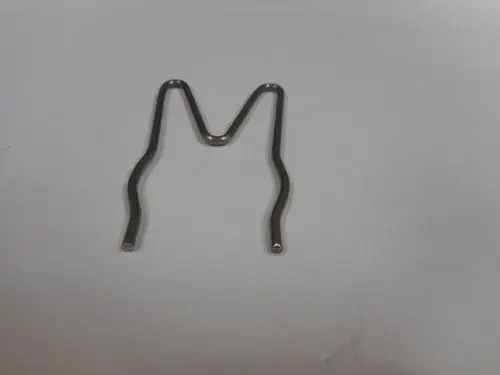 Clip aus Metall in Form eines "M", möglicherweise für einen Brennwerttauscher von Remeha, auf einem weißen Untergrund.